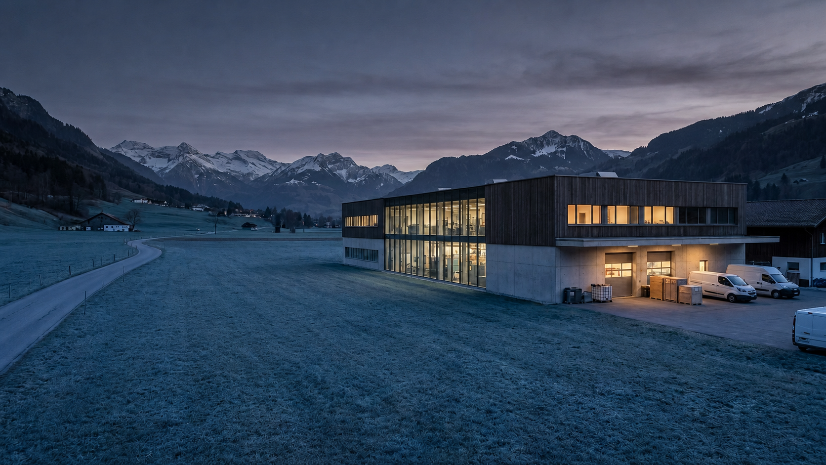 Modern Swiss precision manufacturing facility in an alpine valley at dusk